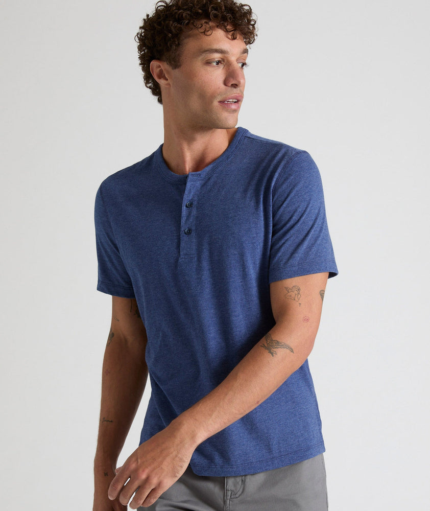 Model is wearing UNTUCKit Jericho henley in solid blue.