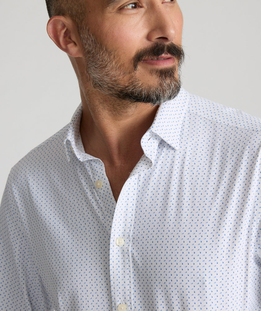 Model is wearing UNTUCKit Mckenzie bluebell shirt in white grounded dot print.