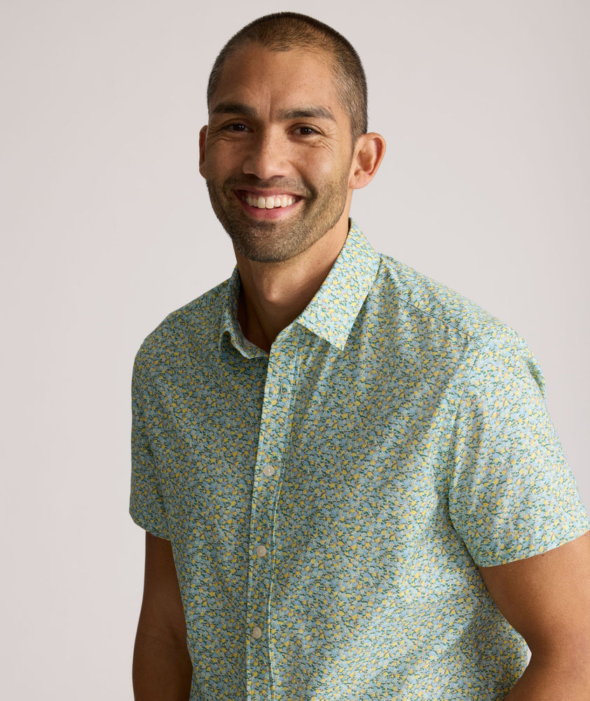 Model is wearing UNTUCKit Yorke performance short sleeve green and yellow floral print shirt.