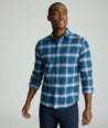 Model is wearing UNTUCKit Barker performance flannel in blue plaid. 