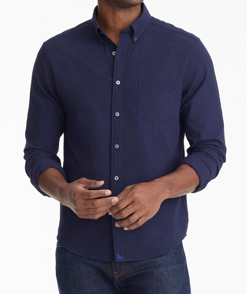 Model is wearing UNTUCKit Cadwell Seersucker shirt in navy.