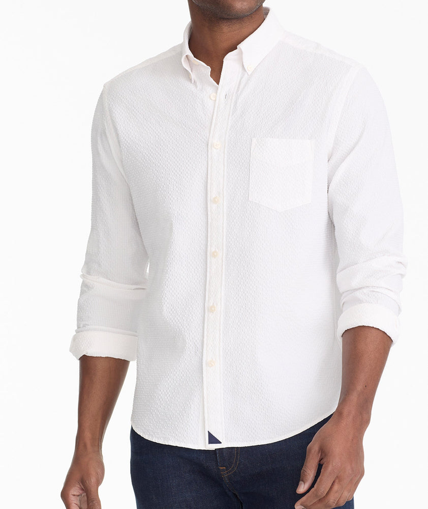 Model is wearing UNTUCKit Cadwell Seersucker shirt in white.