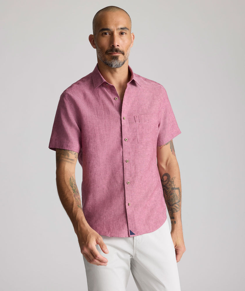 Model is wearing UNTUCKit Wrinkle-Resistant Linen Short-Sleeve Cameron Shirt in fig rose. 