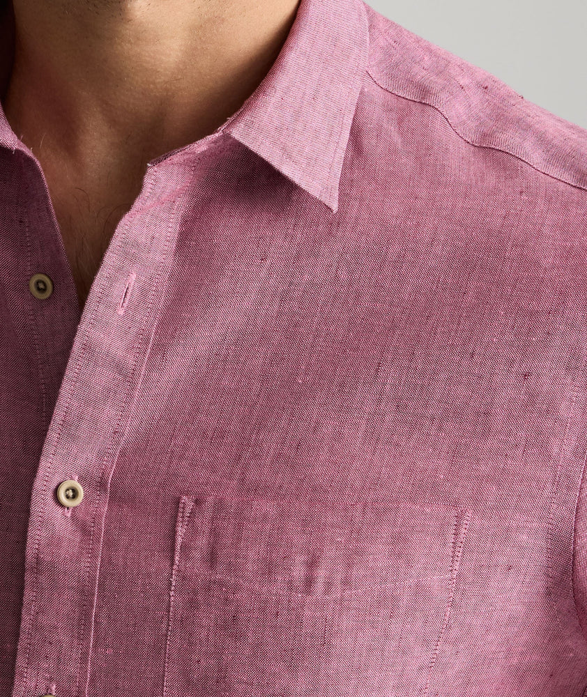 Model is wearing UNTUCKit Wrinkle-Resistant Linen Short-Sleeve Cameron Shirt in fig rose. 
