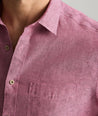Model is wearing UNTUCKit Wrinkle-Resistant Linen Short-Sleeve Cameron Shirt in fig rose. 