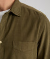 Model is wearing UNTUCKit Caprone Cord Shirt in dark olive.