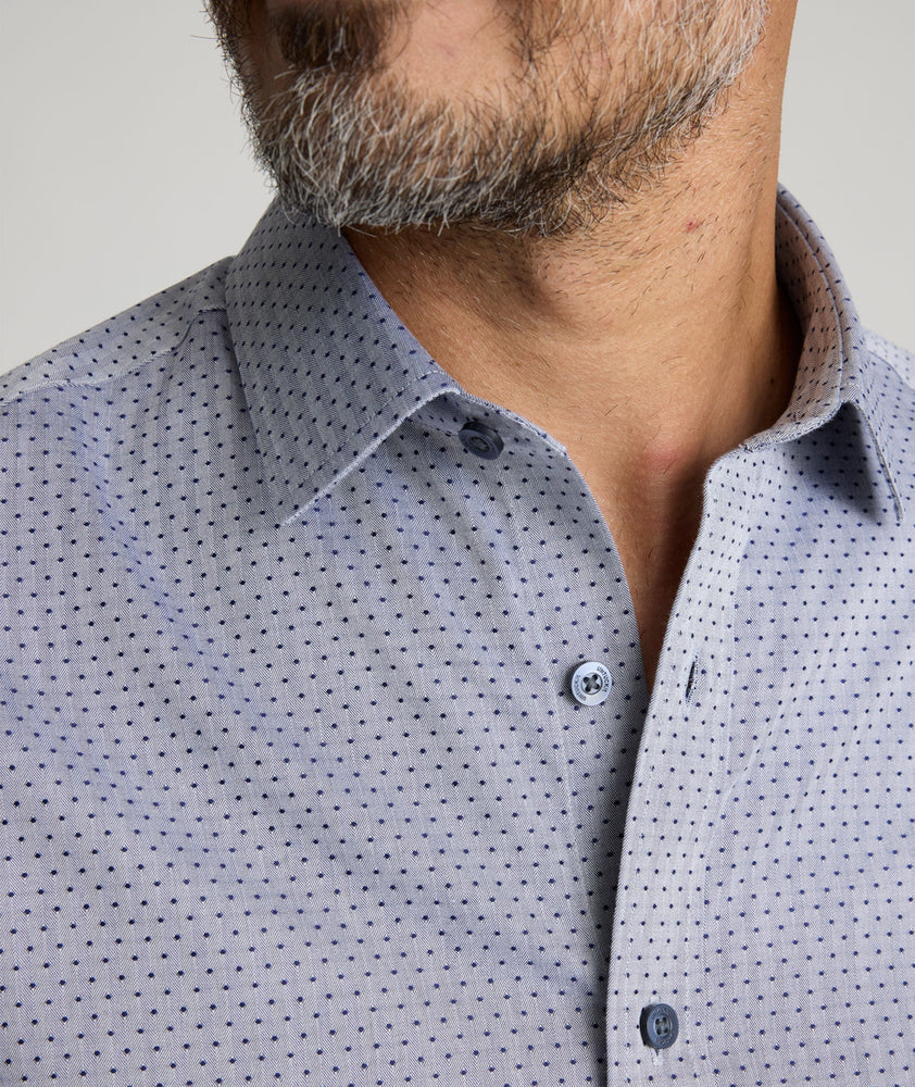 Model is wearing UNTUCKit Daltrey wrinkle-free shirt in gray print. 