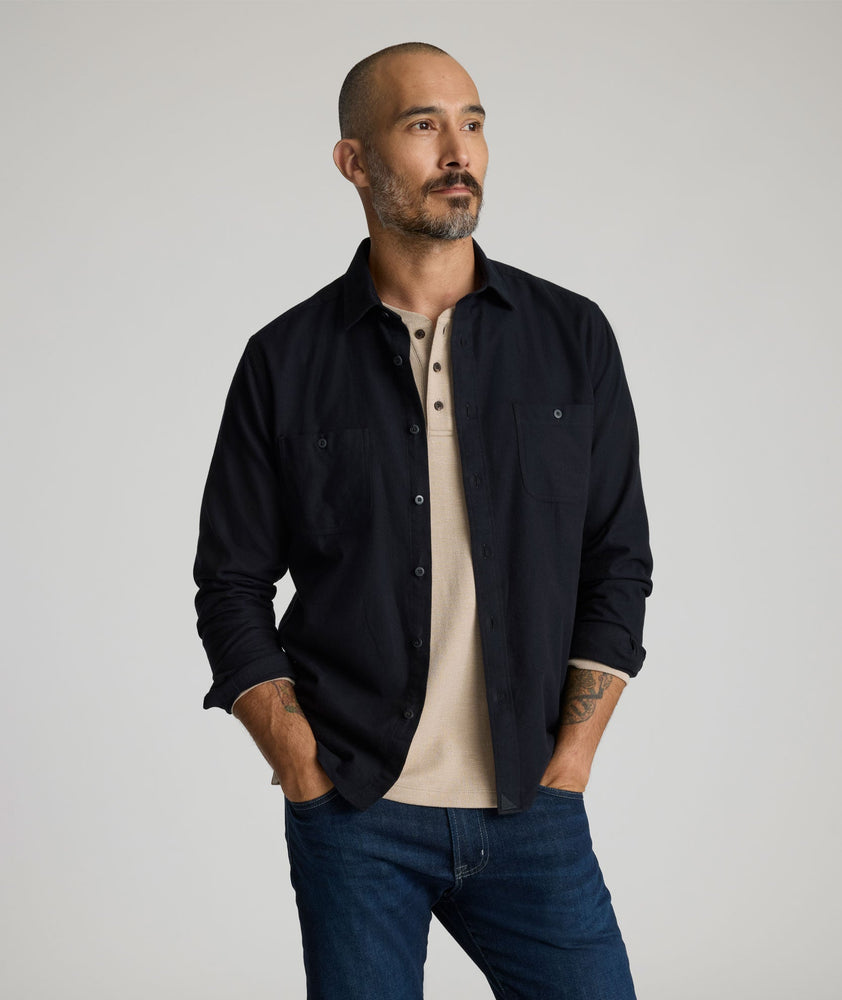 Model is wearing Flannel Hemsworth Shirt in Black Herringbone.