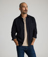 Model is wearing Flannel Hemsworth Shirt in Black Herringbone.