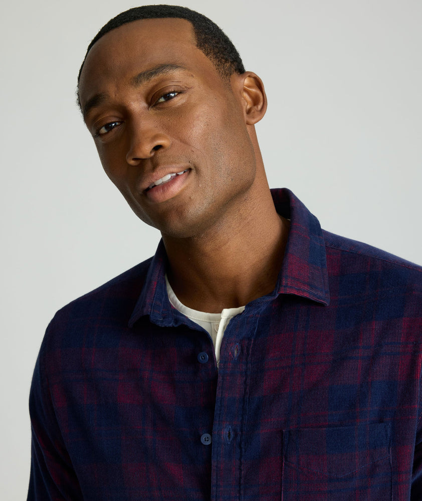 Model is wearing UNTUCKit Cord Shirt in blue and purple plaid. 