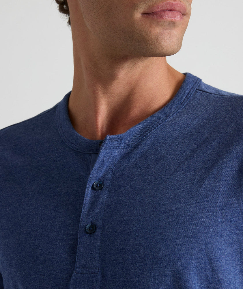 Model is wearing UNTUCKit Jericho henley in solid blue. 