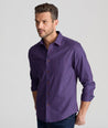 Model is wearing UNTUCKit Knight wrinkle-free long sleeve in maroon and purple navy check.