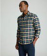 Model is wearing UNTUCKit Flannel Plenville Shirt in green check. 