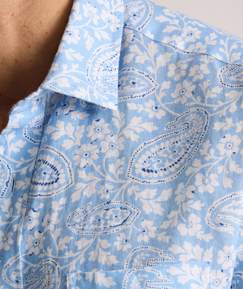 Model is wearing UNTUCKit Turner short sleeve linen shirt in light blue print. 