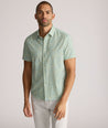 Model is wearing UNTUCKit Yorke performance short sleeve green and yellow floral print shirt. 