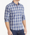 Model is wearing UNTUCKit Navy & Gray Buffalo Check Wrinkle-Free Wheeler Shirt.